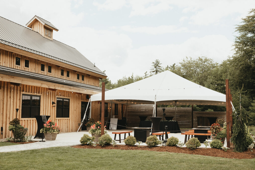 Patio with white tent, cocktail tables and firepirts.